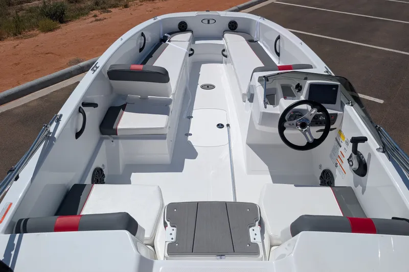 Slide: The Image of 2027 Tahoe T18 boat interior with modern seating and steering console in a parking lot. - 9