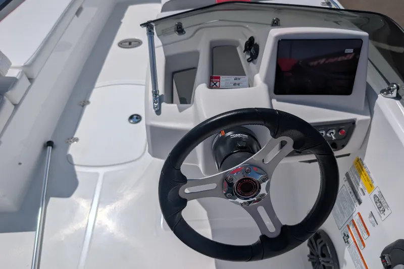 Slide: The Image of Steering wheel and dashboard of 2027 Tahoe T18 boat, featuring modern controls and display. - 13