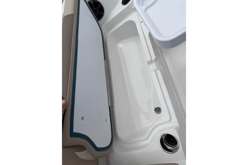 Slide: The Image of 2027 Tahoe 1950 boat storage compartment with open lid and cup holder. - 114