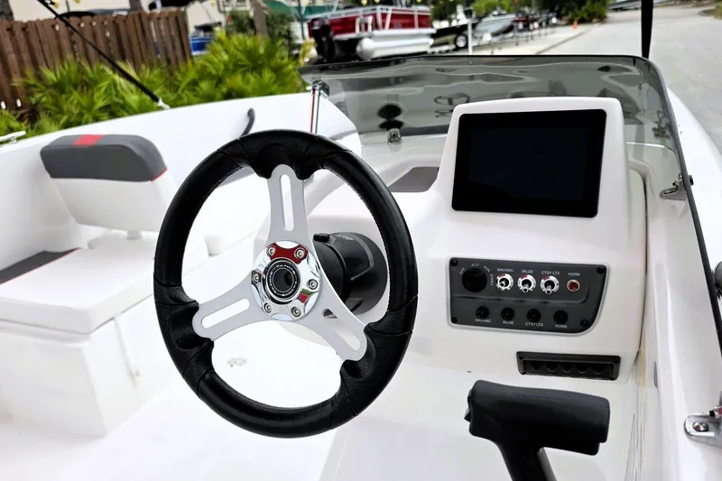 Slide: The Image of 2027 Tahoe T18 boat dashboard with steering wheel and control panel. - 12