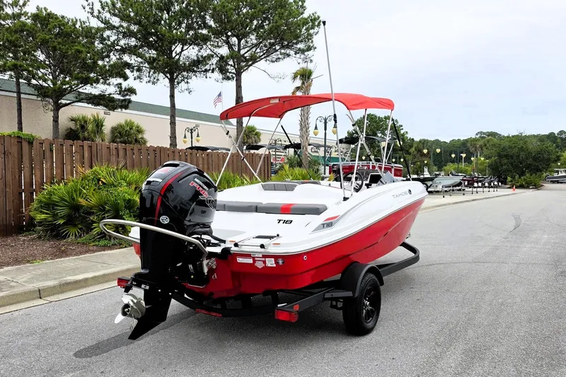 Slide: The Image of 2027 Tahoe T18 boat with red and white design on a trailer, parked outdoors. - 3