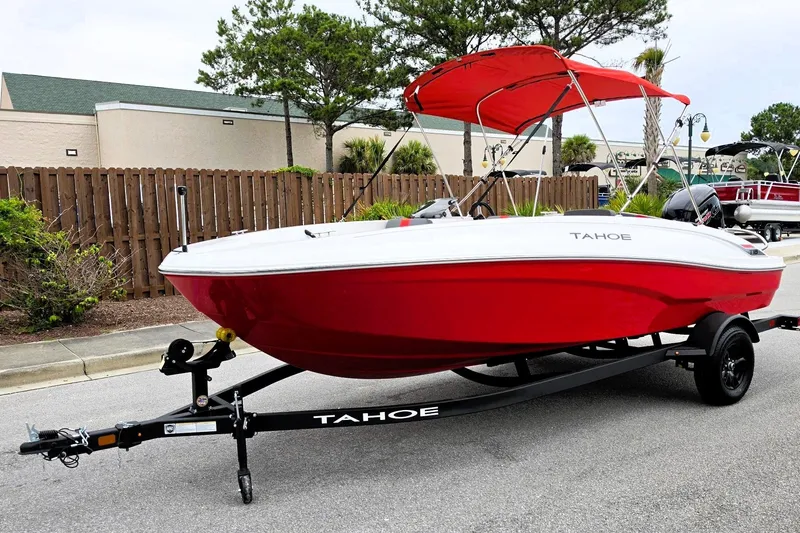 Slide: The Image of Red 2027 Tahoe T18 boat on trailer with canopy, parked outdoors. - 9