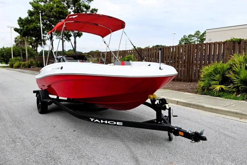 Slide: The Image of Red 2027 Tahoe T18 boat on trailer with canopy, parked on street. - 6