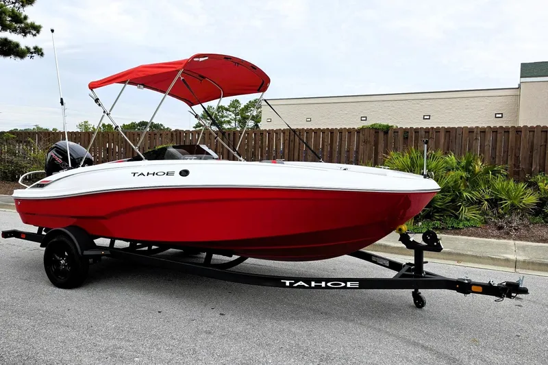 Slide: The Image of Red 2027 Tahoe T18 boat with canopy on trailer, parked outdoors. - 5