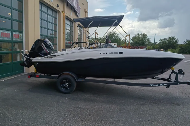 Slide: The Image of 2027 Tahoe T18 boat on trailer, parked outside a service center. - 1