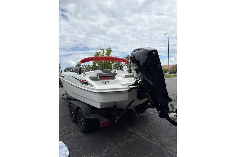 Slide: The Image of 2027 Tahoe T21 boat with outboard motor on trailer, parked outdoors under cloudy sky. - 3