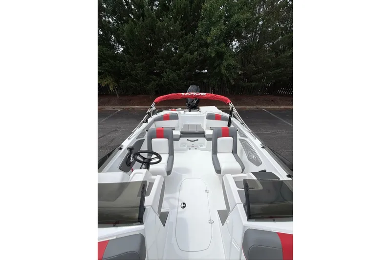 Slide: The Image of 2027 Tahoe T21 boat interior with red and gray seating, parked outdoors. - 9