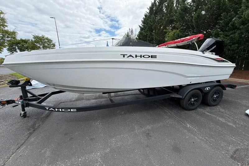 Slide: The Image of 2027 Tahoe T21 boat on trailer, parked outdoors, showcasing sleek white design. - 2