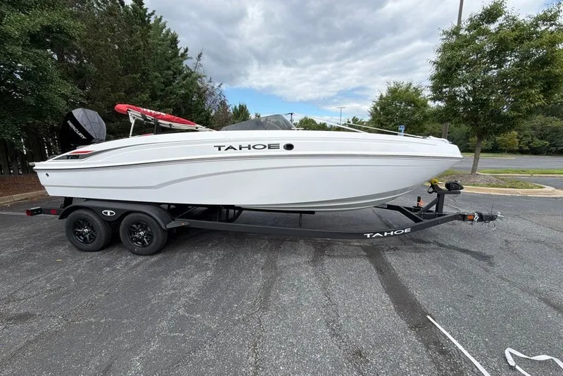 Slide: The Image of 2027 Tahoe T21 boat on trailer, parked outdoors under cloudy sky. - 6