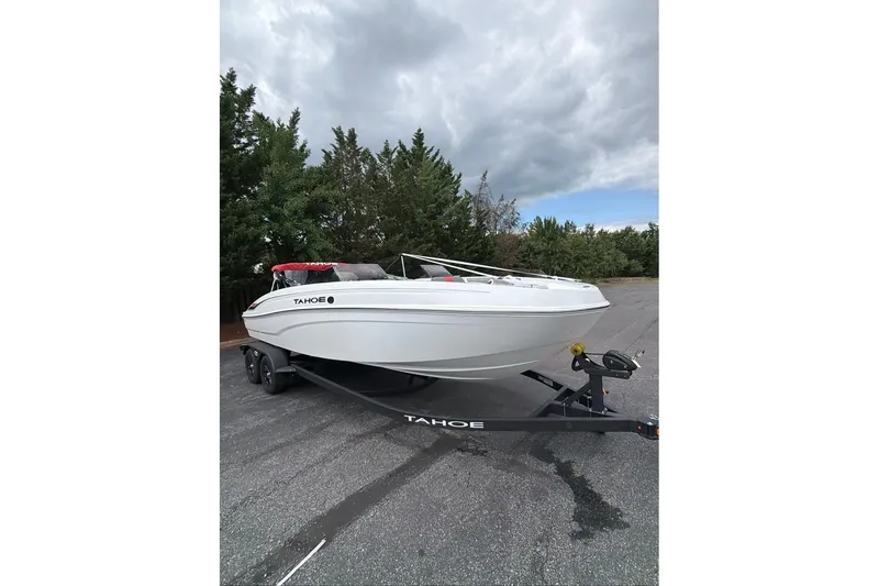 The Image of 2027 Tahoe T21 boat on trailer, parked outdoors under cloudy sky. - 0