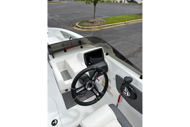 Slide: The Image of 2027 Tahoe T21 boat cockpit with steering wheel and control panel in a parking lot. - 11