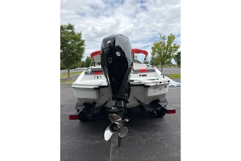 Slide: The Image of 2027 Tahoe T21 boat with outboard motor, parked on asphalt under cloudy sky. - 4