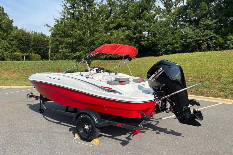 Slide: The Image of 2027 Tahoe T16 boat with red and white design, parked on a trailer outdoors. - 3
