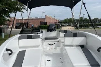 Slide: The Image of 2027 Tahoe T16 boat with seating, canopy, and motor in a marina setting. - 2