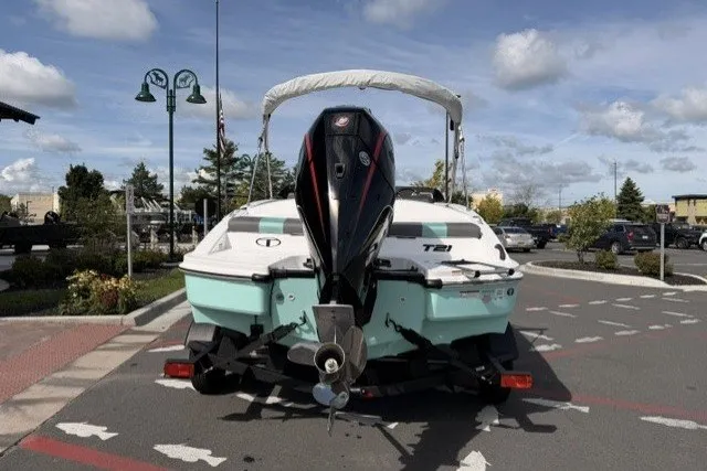 Slide: The Image of 2027 Tahoe T21 boat on trailer in parking lot, under a partly cloudy sky. - 1