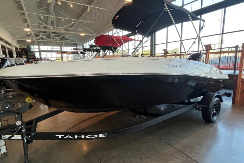 Slide: The Image of 2027 Tahoe T18 boat displayed indoors, featuring sleek black and white design. - 1