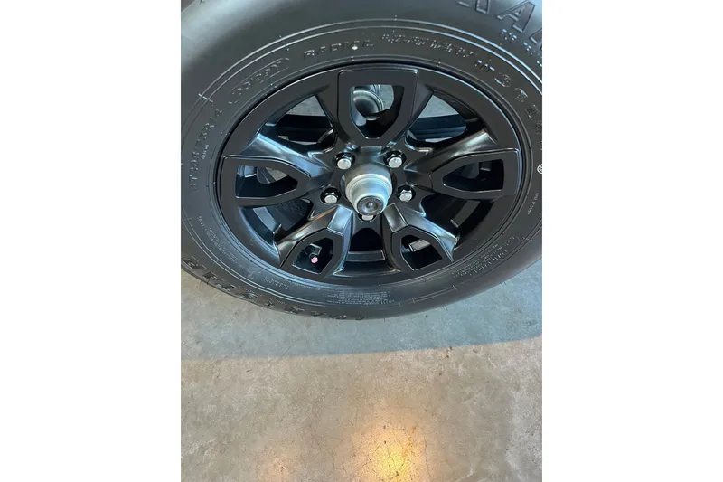 Slide: The Image of 2027 Tahoe T18 black alloy wheel on concrete floor. - 10