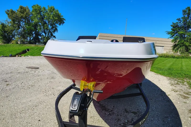 Slide: The Image of Red and white 2027 Tahoe T21 boat on trailer, parked outdoors under clear blue sky. - 3