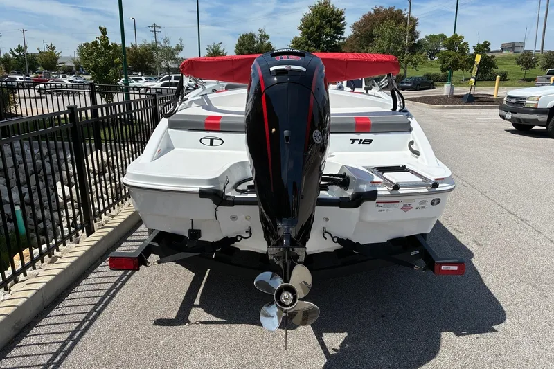Slide: The Image of 2027 Tahoe T18 boat with outboard motor, parked on a trailer in a lot. - 4