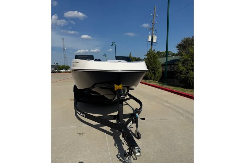 Slide: The Image of 2027 Tahoe T21 boat on trailer under clear blue sky. - 2