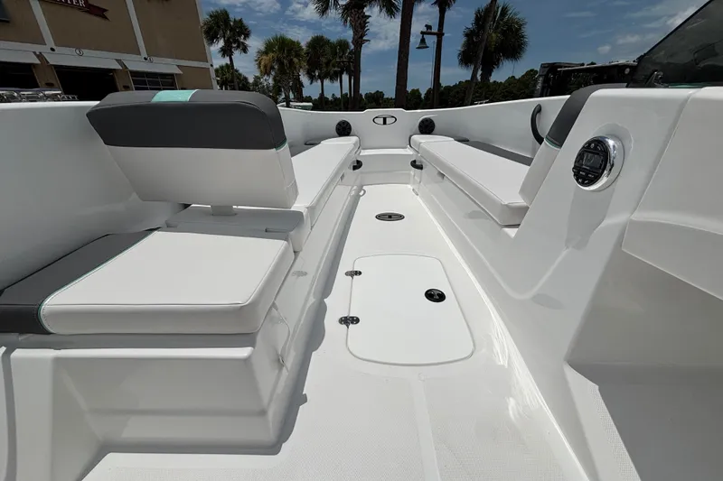 Slide: The Image of 2027 Tahoe T18 boat interior with seating, white and gray upholstery, and palm trees in the background. - 12