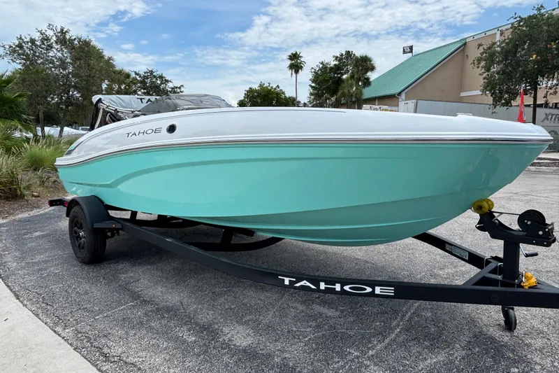 Slide: The Image of 2027 Tahoe T18 boat on trailer, turquoise hull, parked outdoors under a cloudy sky. - 8
