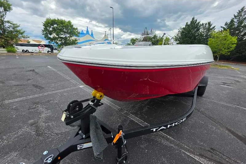 Slide: The Image of 2027 Tahoe T18 boat with red hull on a trailer in a parking lot. - 76