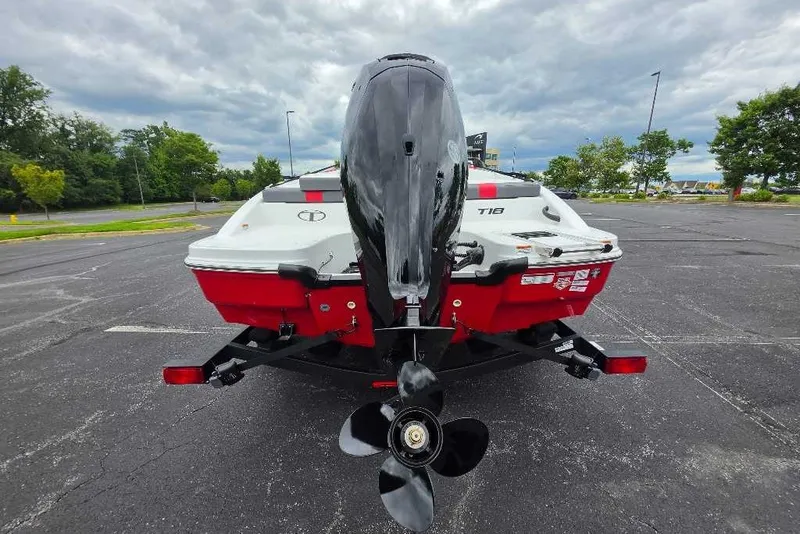 Slide: The Image of 2027 Tahoe T18 boat on trailer, rear view with outboard motor, parked outdoors. - 2