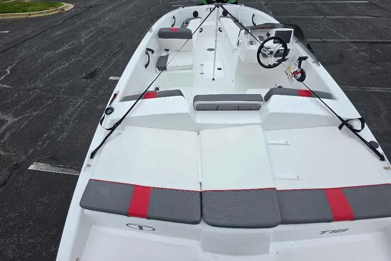 Slide: The Image of 2027 Tahoe T18 boat with sleek design, red and gray seating, parked on asphalt. - 10