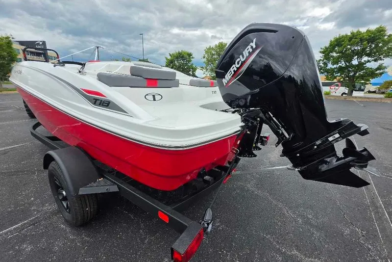 Slide: The Image of 2027 Tahoe T18 boat with Mercury outboard motor on a trailer in a parking lot. - 1