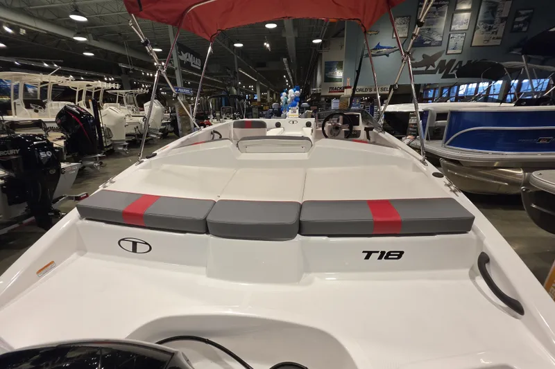 Slide: The Image of 2027 Tahoe T18 boat interior with red and gray seating, displayed in a showroom. - 5