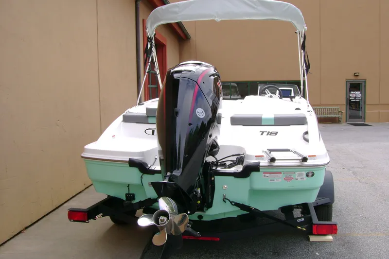 Slide: The Image of 2027 Tahoe T18 boat with outboard motor, parked outside a building. - 7