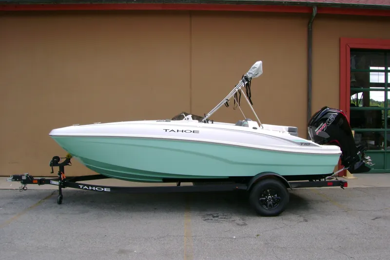 Slide: The Image of 2027 Tahoe T18 boat on trailer, mint green hull, parked outdoors. - 1