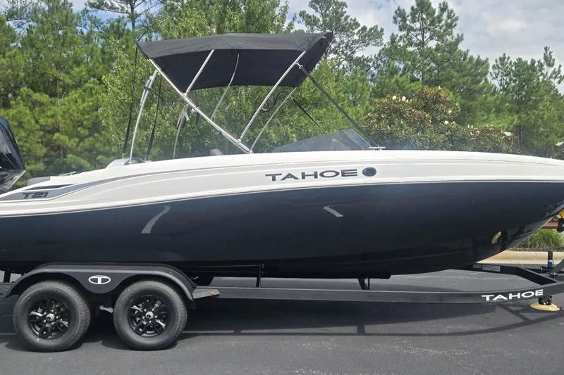 The Image of 2027 Tahoe T21 boat on trailer, black and white design, parked outdoors. - 0