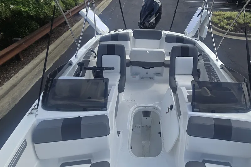 Slide: The Image of 2027 Tahoe T21 boat interior with seating and steering wheel, parked on pavement. - 2