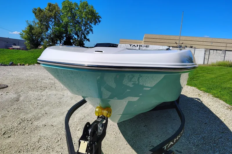 Slide: The Image of 2027 Tahoe T18 boat on trailer, parked outdoors on gravel, under clear blue sky. - 1