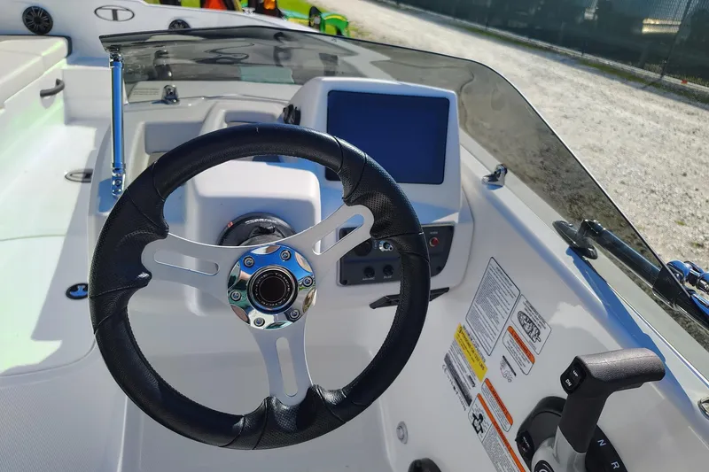 Slide: The Image of Steering wheel and dashboard of a 2027 Tahoe T18 boat, featuring modern controls. - 8