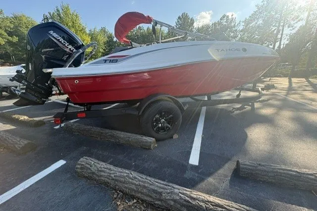 The Image of 2027 Tahoe T18 boat with red and white design on a trailer in a parking lot. - 0