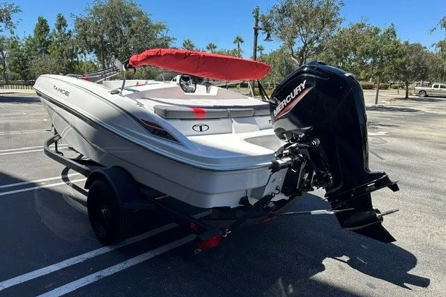 Slide: The Image of 2027 Tahoe T18 boat with Mercury engine, parked outdoors on a trailer. - 5