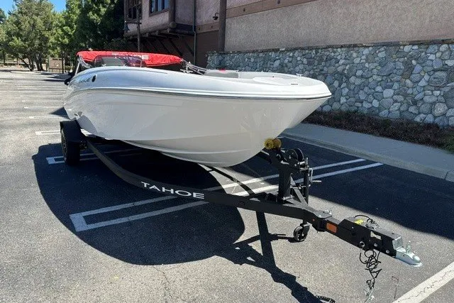 Slide: The Image of 2027 Tahoe T18 boat on trailer in parking lot, featuring sleek white design. - 3