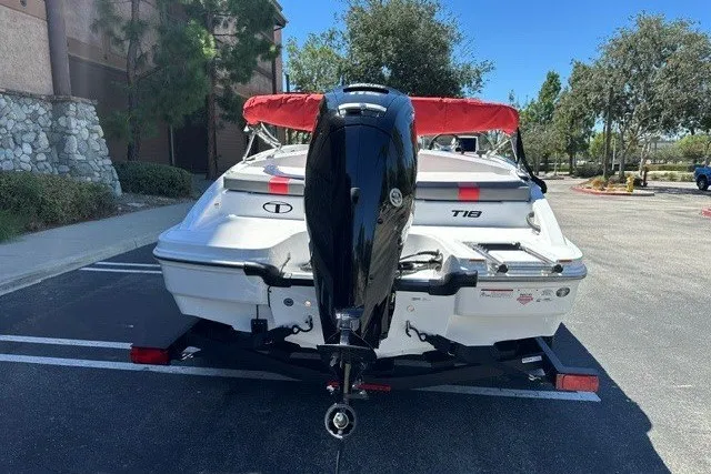 Slide: The Image of 2027 Tahoe T18 boat with outboard motor, parked outdoors on a sunny day. - 6