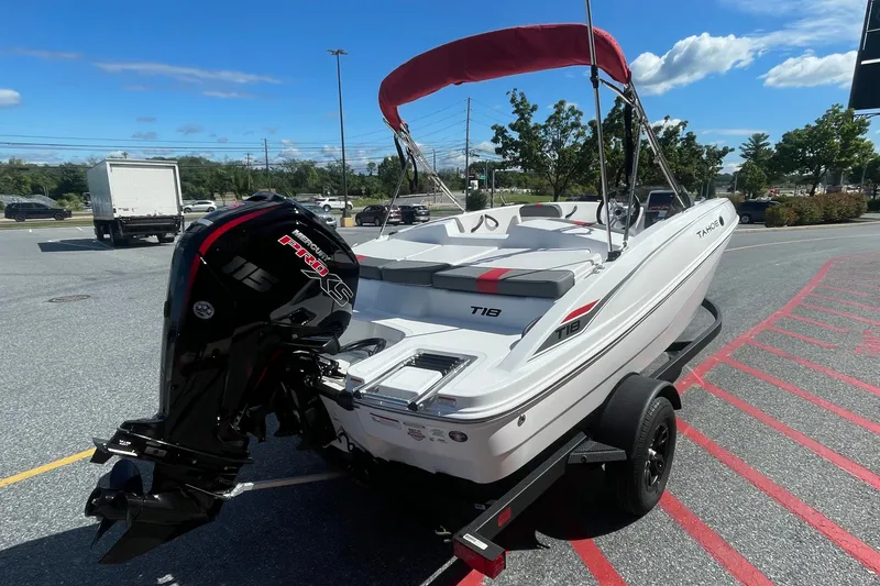 Slide: The Image of 2027 Tahoe T18 boat with outboard motor on a trailer in a parking lot. - 1
