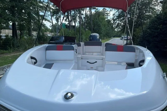 Slide: The Image of 2027 Tahoe T16 boat with red canopy and spacious seating, parked outdoors. - 4