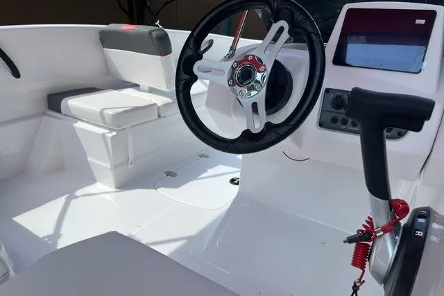Slide: The Image of Interior of a 2027 Tahoe T16 boat featuring steering wheel and seating area. - 9