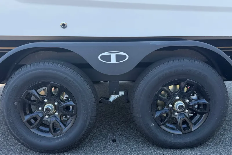 Slide: The Image of 2027 Tahoe T21 trailer wheels with black alloy rims on asphalt surface. - 9