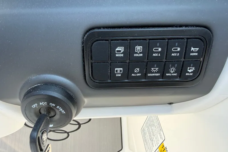 Slide: The Image of Dashboard controls of a 2027 Tahoe T21 boat, featuring various function buttons and ignition switch. - 7