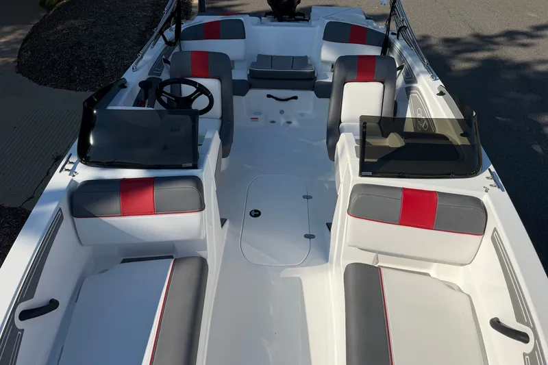 Slide: The Image of 2027 Tahoe T21 boat interior with red and gray seating, steering wheel, and windshields. - 3
