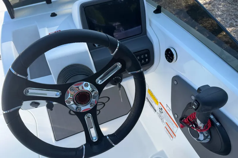 Slide: The Image of Steering wheel and controls of 2027 Tahoe T21 boat, featuring modern dashboard design. - 2