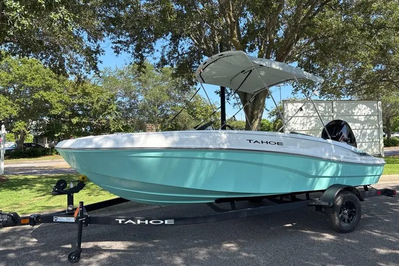 The Image of 2027 Tahoe T18 boat on trailer, parked under trees, featuring a sleek design and canopy. - 0