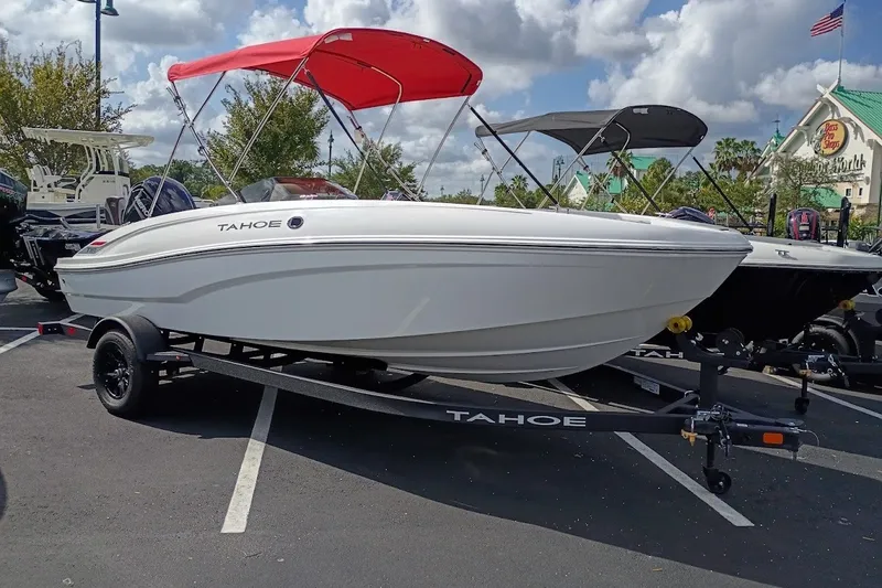 The Image of 2027 Tahoe T18 boat with red canopy on trailer in parking lot. - 0